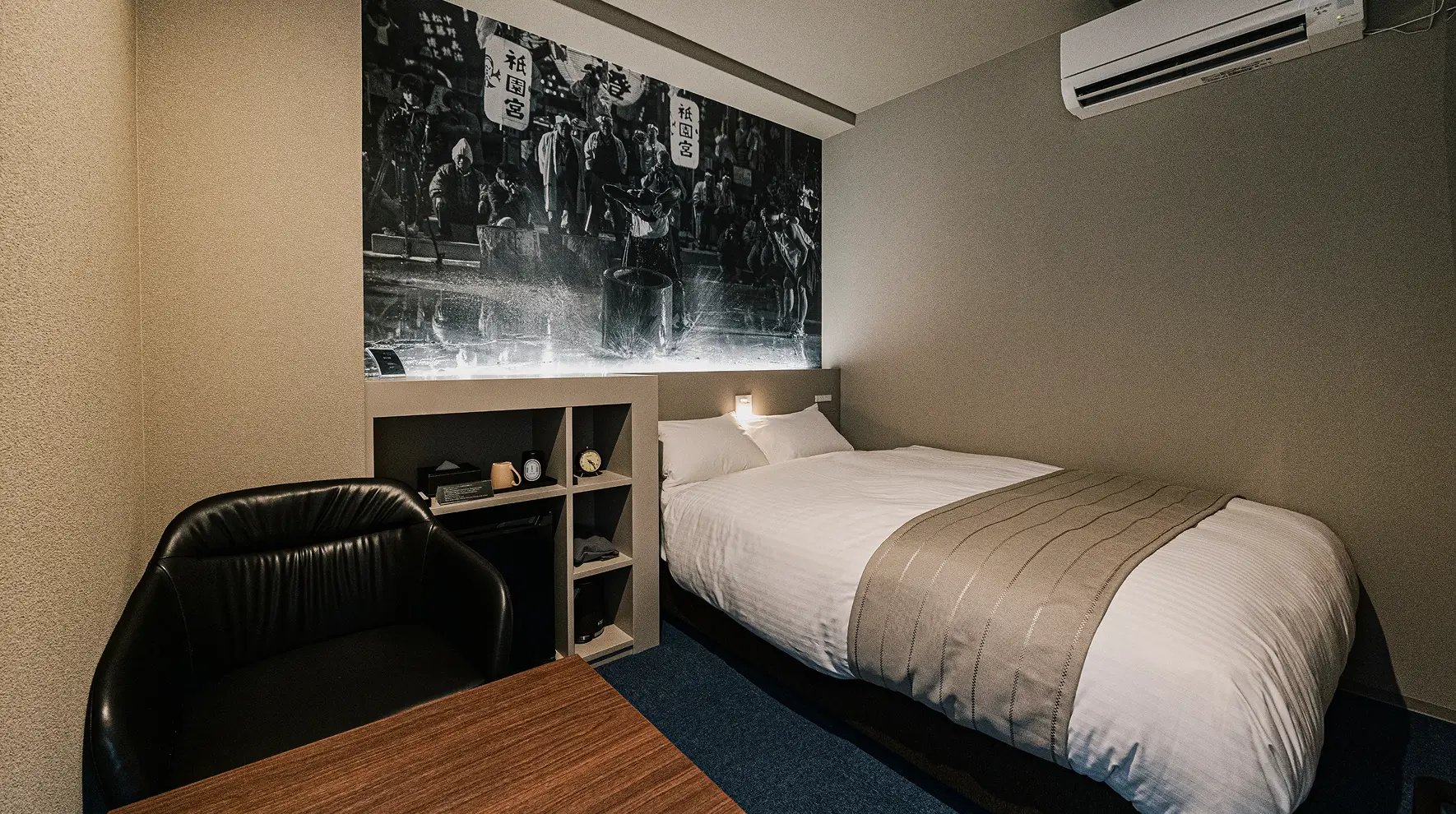 Hotel room with a bed, desk, and wall art.